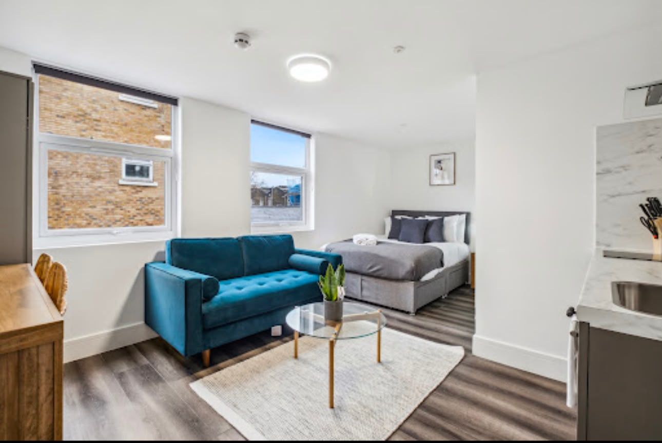 Sitting area with teal sofa beside the bed