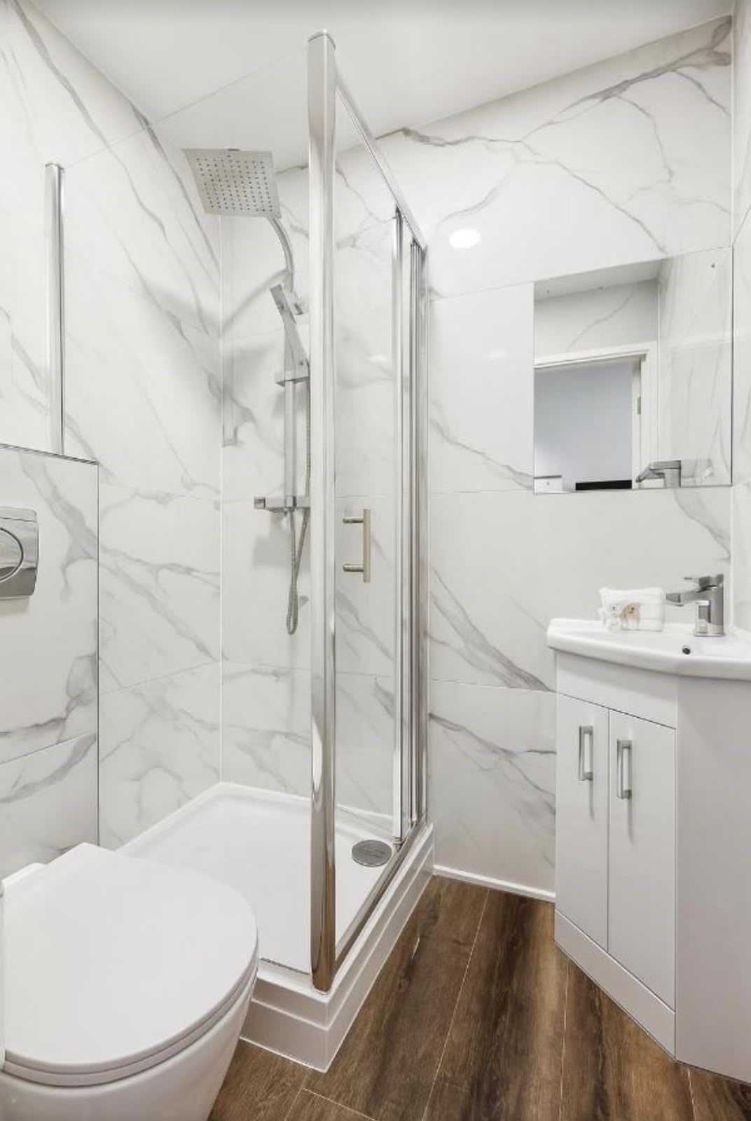 Shower room with marble-effect tiling and a white vanity unit