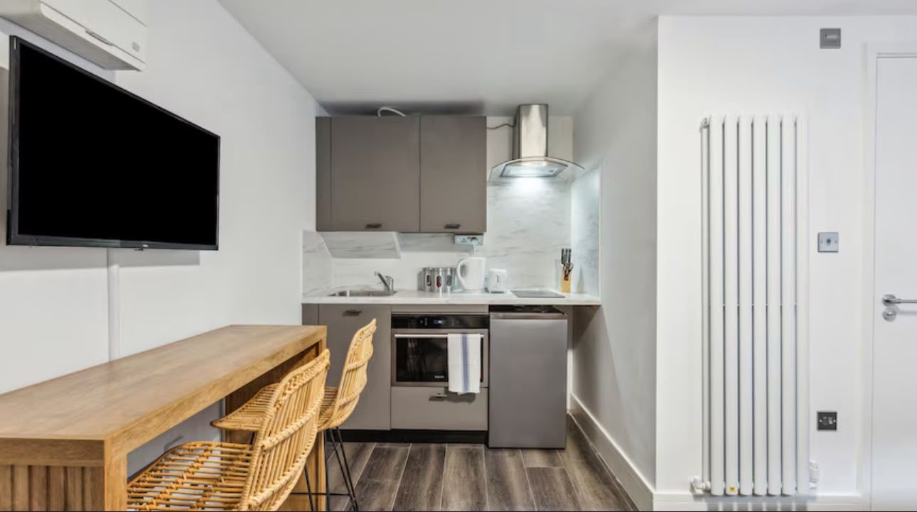 Kitchen wall with oven, extractor, television and dining bar